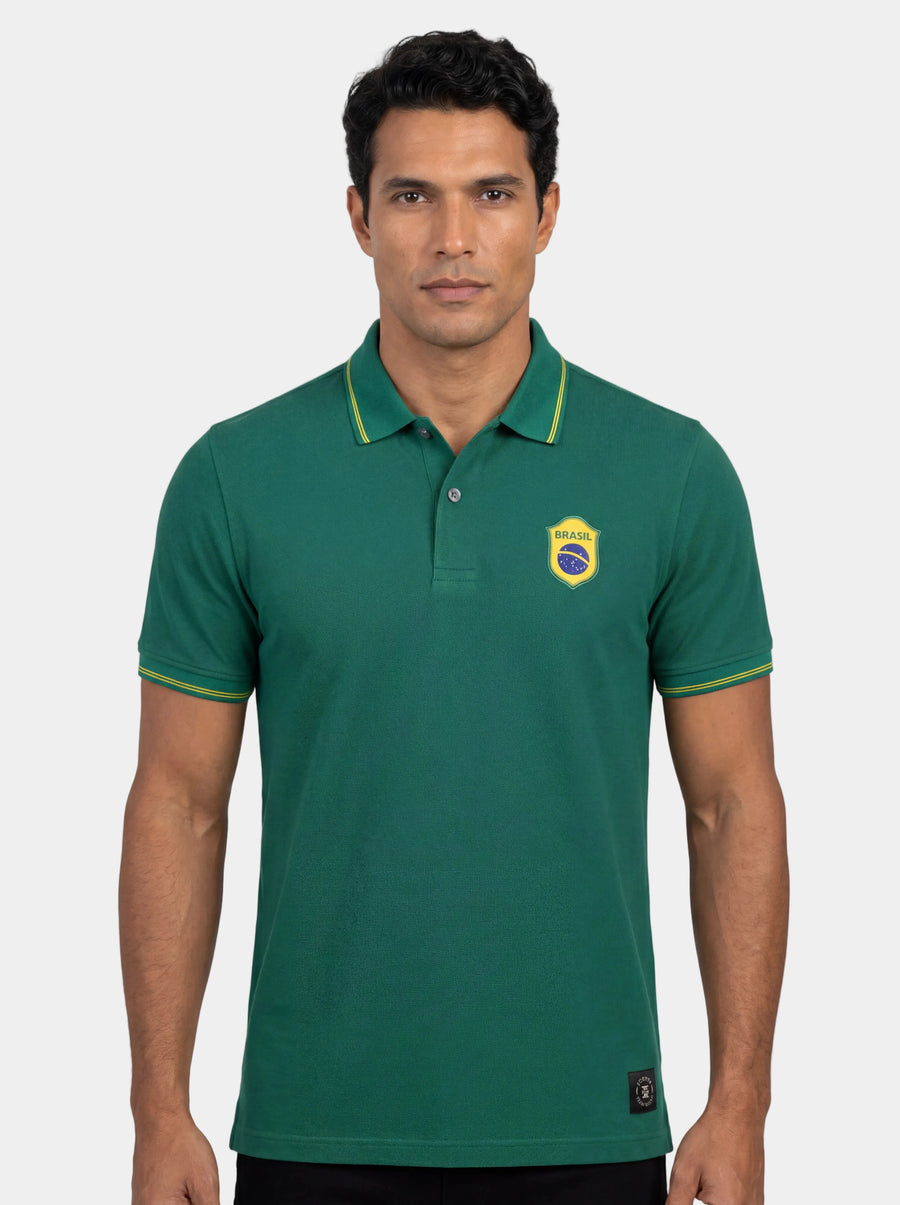 Man wearing a green polo shirt with a logo on a white background