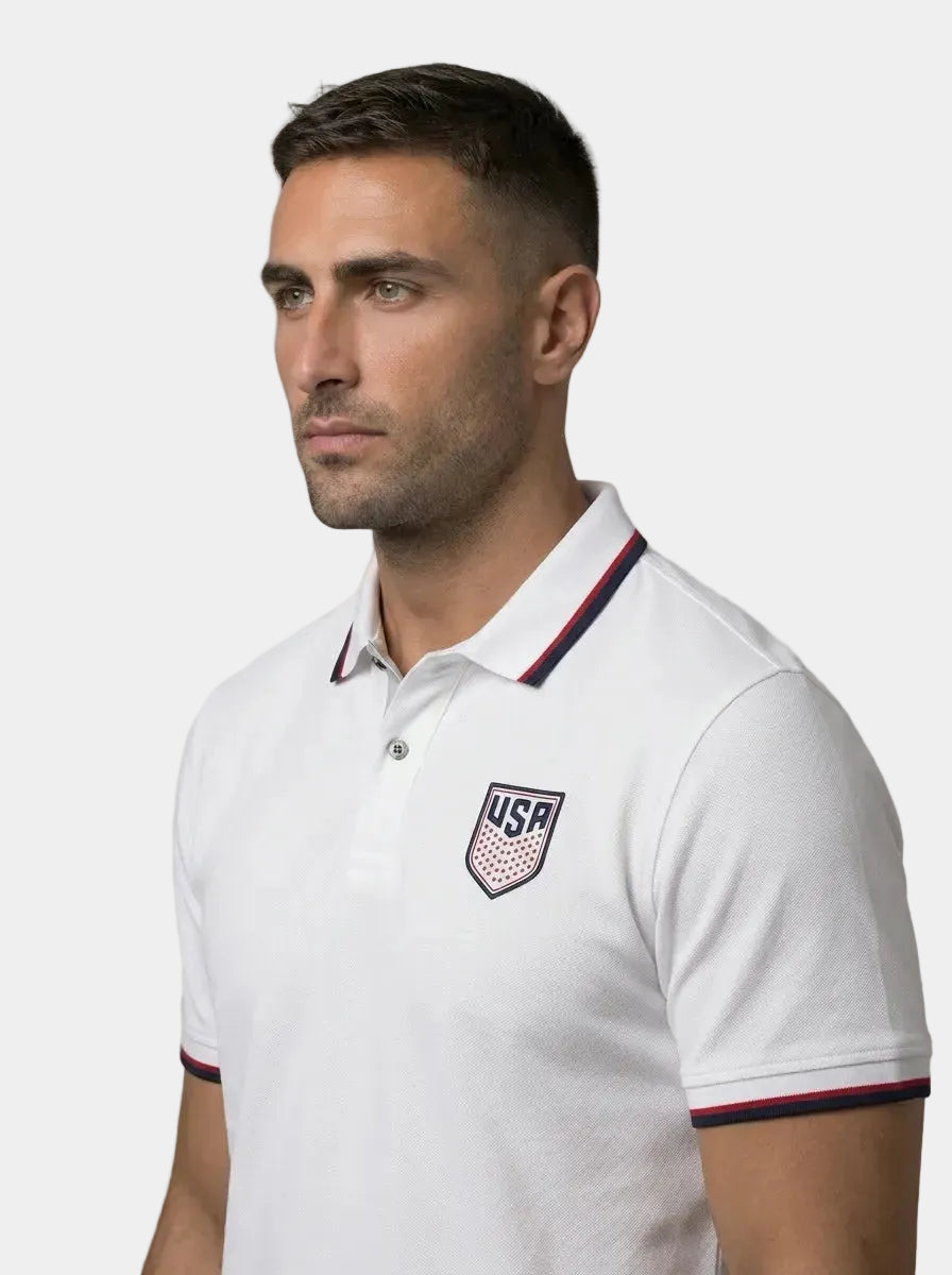 Man wearing a white polo shirt with USA logo on a gray background