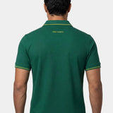 Man wearing a green polo shirt with a visible brand logo on the back against a white background
