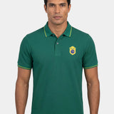 Man wearing a green polo shirt with a logo on a white background