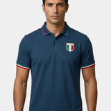 Man wearing a navy blue polo shirt with a logo on a white background