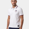 Man wearing a white polo shirt with a logo on a white background