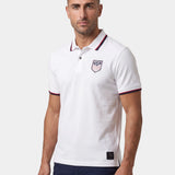 Man wearing a white polo shirt with a logo on a white background