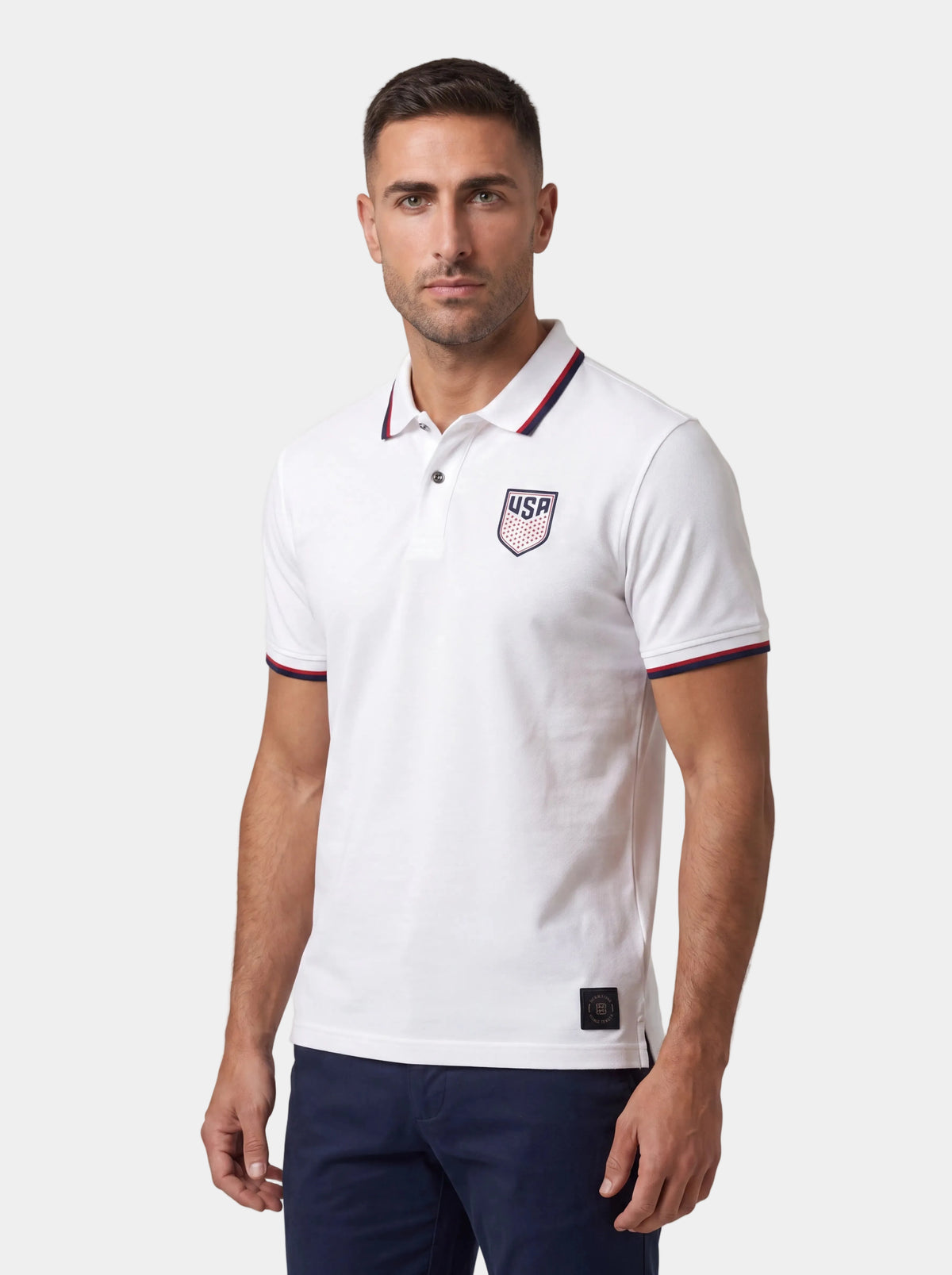 Man wearing a white polo shirt with a logo on a white background